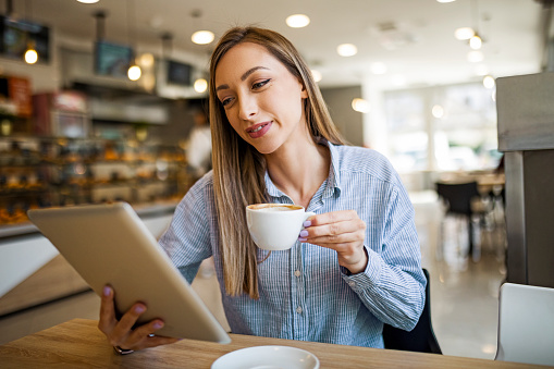 Businesswoman Having Morning Coffee Using Digital Tablet