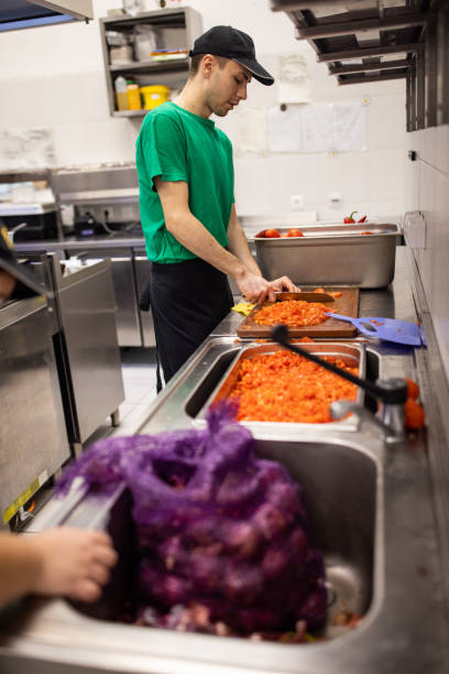 istock Chef cutting tomato in the fast food restaurant kitchen 1388743011