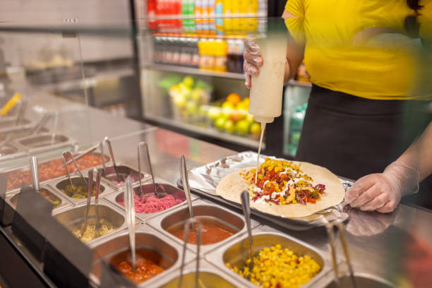 istock Unrecognizable Caucasian female fast food worker, making burrito 1388745172
