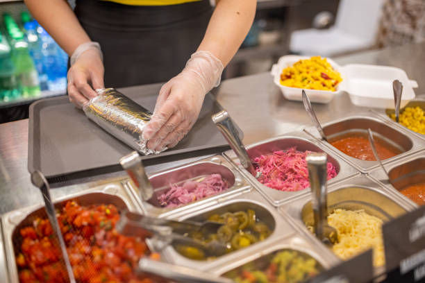 istock Unrecognizable Caucasian female fast food worker, making burrito 1388745950