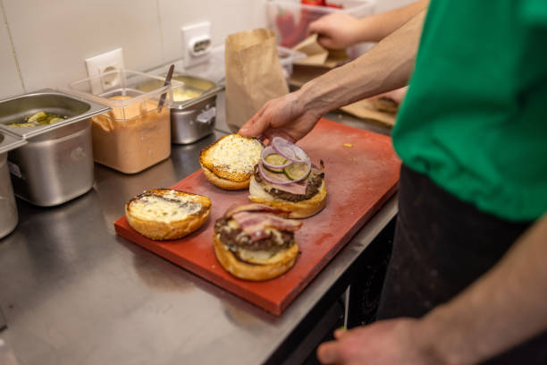 istock Unrecognizable chef, making the burger at the fast food restaurant kitchen 1388746548