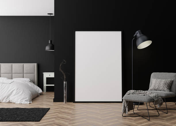 istock Empty vertical picture frame standing on parquet floor in modern bedroom. Mock up interior in minimalist, contemporary style. Free space for picture or poster. Bed, armchair, lamp. 3D rendering. 1388751396