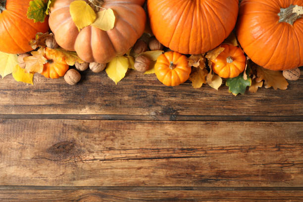 istock Flat lay composition with ripe pumpkins and autumn leaves on wooden table, space for text. Happy Thanksgiving day 1388753948