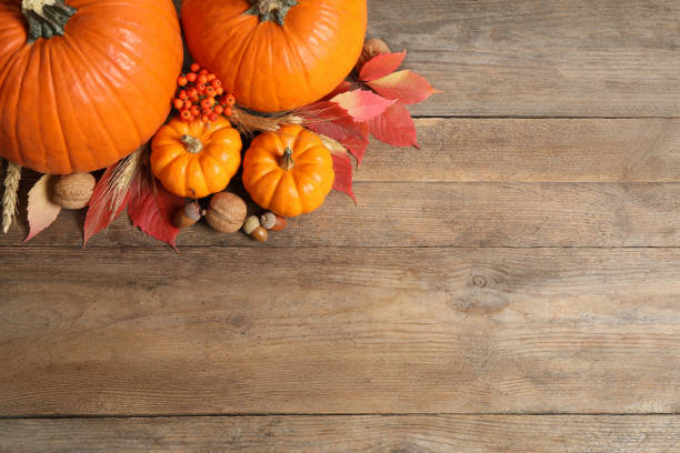 istock Flat lay composition with ripe pumpkins and autumn leaves on wooden table, space for text. Happy Thanksgiving day 1388754003