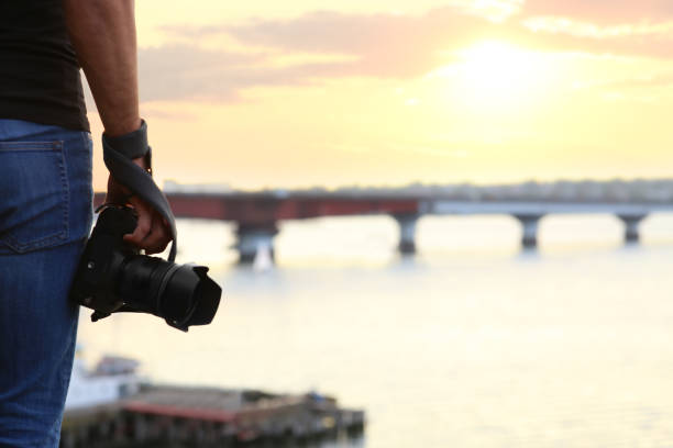 istock Photographer with professional camera near river, closeup 1388754520