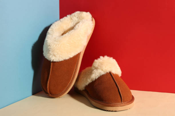 istock Pair of soft slippers on color background 1388755137