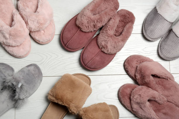istock Many different soft slippers on white wooden background, flat lay 1388755481