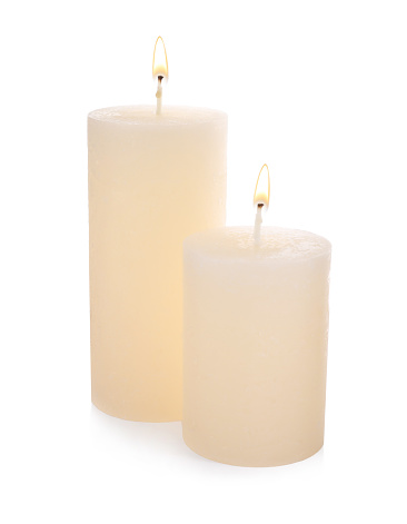 Stylish elegant beige candles on white background