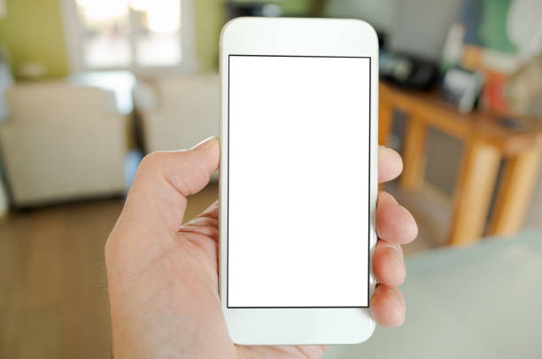 POV shot using a smart phone with blank screen in a modern living room - for e.g. smart home automation or energy usage application. White screen for insertion of graphic.