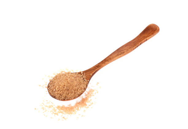 istock Wooden spoon with cane sugar on a white background. 1388757841