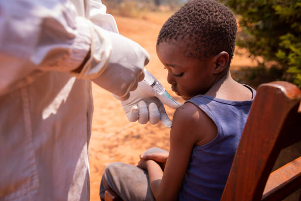 primo piano di un medico che inietta il vaccino a un bambino in africa - ebola foto e immagini stock