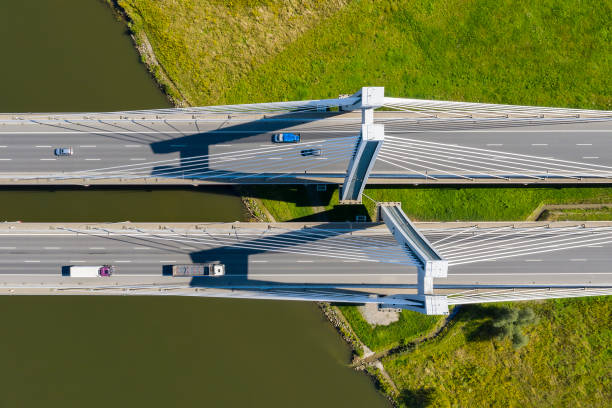 istock White Suspension Bridge over River with Traffic, Aerial View 1388770729