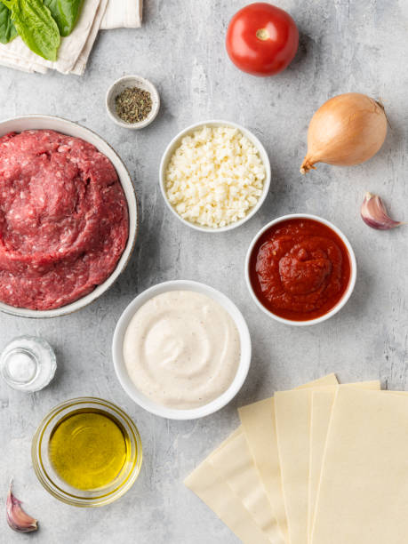 ingredientes de lasaña vista superior. carne molida (picada), queso mozzarella, salsa de tomate, salsa bechamel, aceite de oliva, bulbo de cebolla, dientes de ajo, albahaca. - salsas aderezo fotografías e imágenes de stock