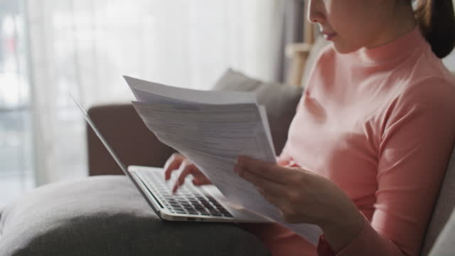 Young woman paying online bills on Laptop at home
