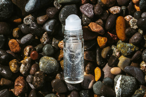 istock Flat lay composition of a roll on transparent deodorant bottle on wet beach stones . Fresh ocean scented product mock up 1388774503