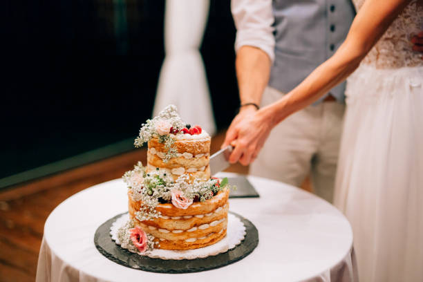istock Midsection Of Bridegroom Cutting Cake 1388776198