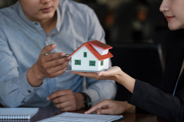 Real estate agent sales manager holding house model to customer after signing rental lease contract of sale purchase agreement, concerning mortgage loan offer for and house insurance. agente de bienes raíces gerente de ventas sosteniendo modelo de casa al cliente después de firmar el contrato de arrendamiento de alquiler de la venta de contrato de compra, en relación con la oferta de préstamo hipotecario y el seguro de la casa