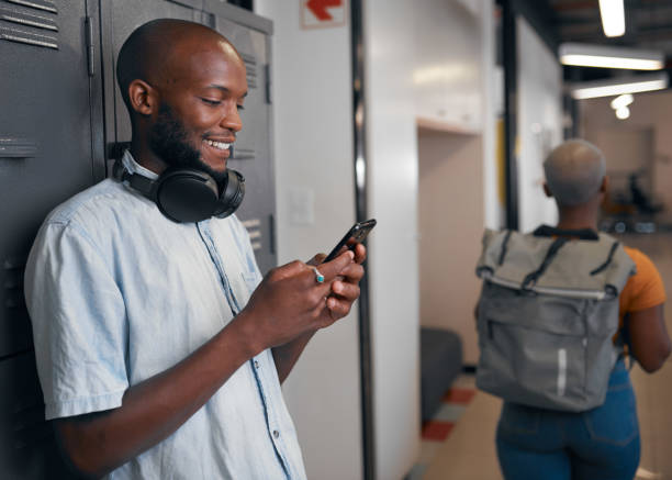 istock A young trendy black student on his mobile phone, woman walks past 1388777965