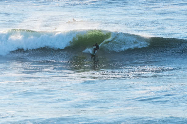 The ocean is calm and the waves are small. The water is blue and the sky is clear
