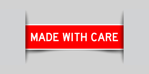 Inserted red color label sticker with word made with cae on gray background