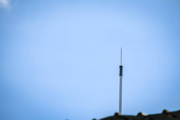 Lamp pole and signal tower with sky and clouds background
