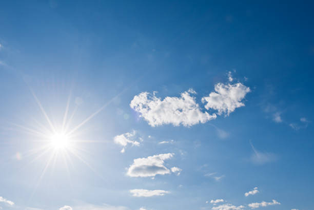 istock Sunny background, blue sky with white clouds and sun 1388784752
