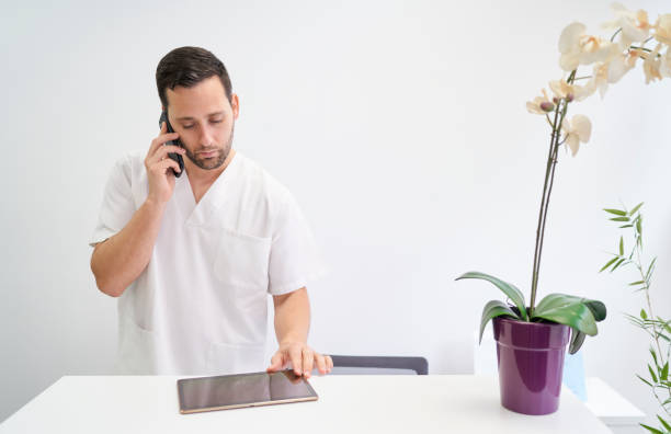 a physiotherapist attending to his patients by telephone stock photo
