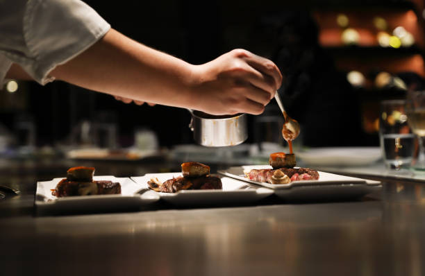 Teppanyaki style. Teppanyaki chef cooking in front of guests. gourmet stock pictures, royalty-free photos & images