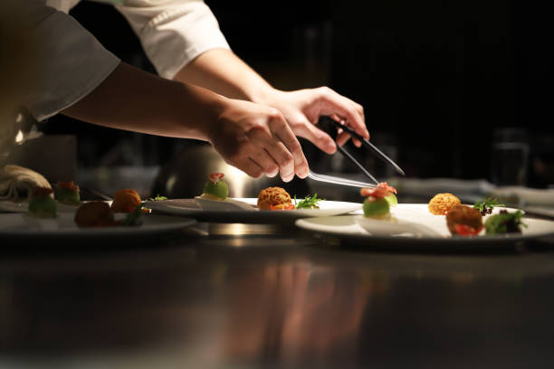 Teppanyaki style. Teppanyaki chef cooking in front of guests. silver service stock pictures, royalty-free photos & images