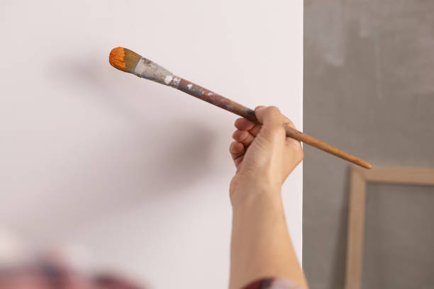 istock Artist working on painting. Painter hand and brush in creative studio 1388795561
