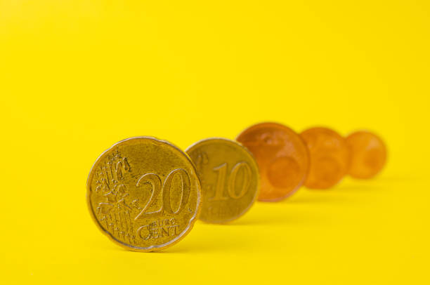 istock Row of euro cent coins on yellow background. Front focus 1388797845