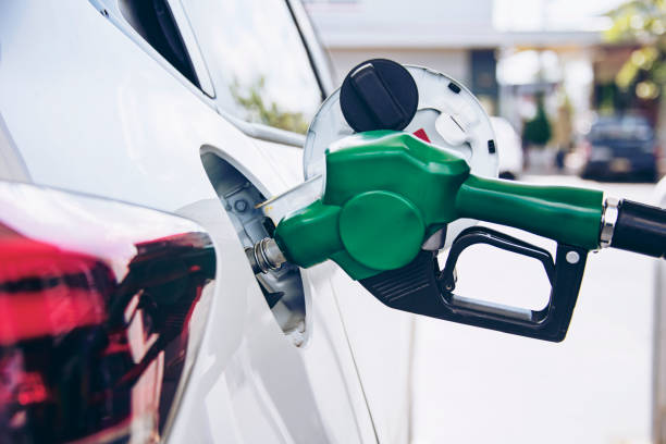 alça verde bombeando bocal de combustível de gasolina para reabastecer. instalações de abastecimento de veículos no posto de gasolina. carro branco no posto de gasolina cheio de combustível. conceito de transporte e propriedade - truck close up fuel tanker semi truck - fotografias e filmes do acervo