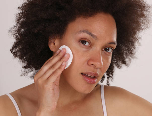 Young woman remove makeup close up. Skin care routine concept stock photo