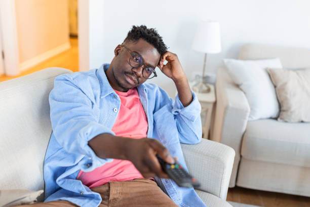 istock Excited African American Man Pointing Television Controller To Camera Switching Channels Watching TV . Television Programming Advertisement. Selective Focus 1388800296