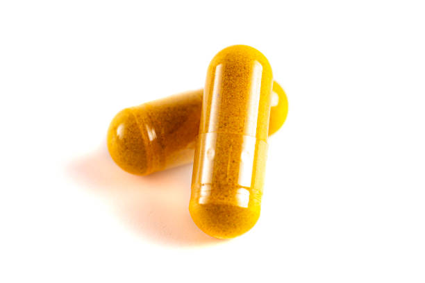 istock Ground Turmeric in Capsule form Isolated on a White Background 1388802803