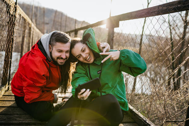 счастливая пара делает селфи на мосту - couple autumn embracing bridge стоковые фото и изображения