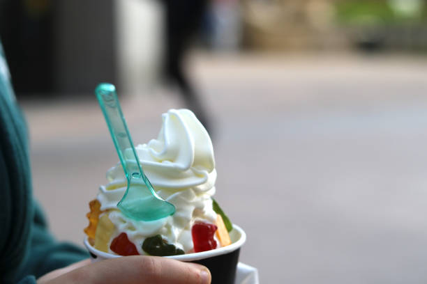 Ice cream with jelly beans in the hand of a child Ice cream with jelly beans in the hand of a child frozen yoghurt stock pictures, royalty-free photos & images