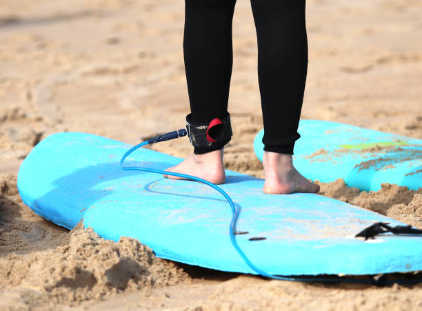 istock Board leash, young people surfing on the beach in summer 1388808663