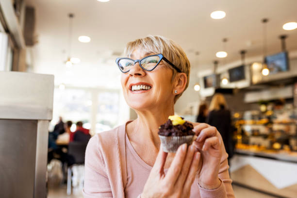 Senior woman eating cupcake