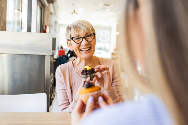 istock Women talking over cupcake in bakery 1388809291