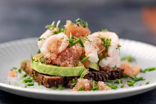 Photo of Fish Roe With Avocado and Prawns on Rye Bread.