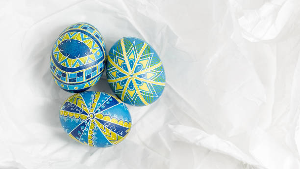 Blue and Yellow like Ukrainian flag Easter eggs Ukrainian Easter eggs Pysanky on the white crumpled paper background. Blue and Yellow like Ukrainian flag Easter eggs decorated with traditional wax-resist dyeing technique ukrainian culture stock pictures, royalty-free photos & images