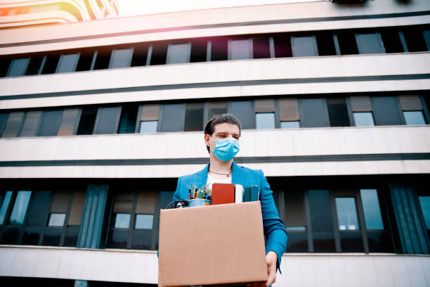 istock Fired male Employee with face mask leaving office building 1388814947