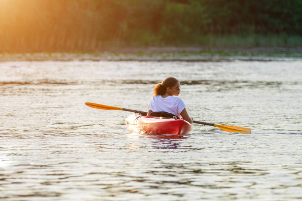 istock Woman kayaking on river alone with sunset on background 1388816388