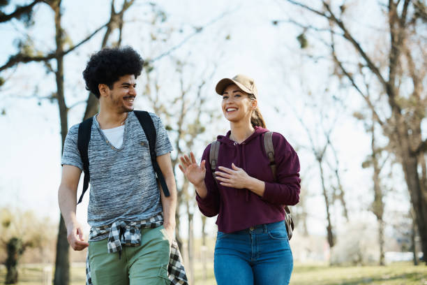 istock Happy multiracial couple talking while walking through the park. 1388816427