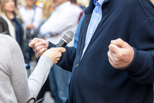 Reporter making media or vox pop with unrecognizable person