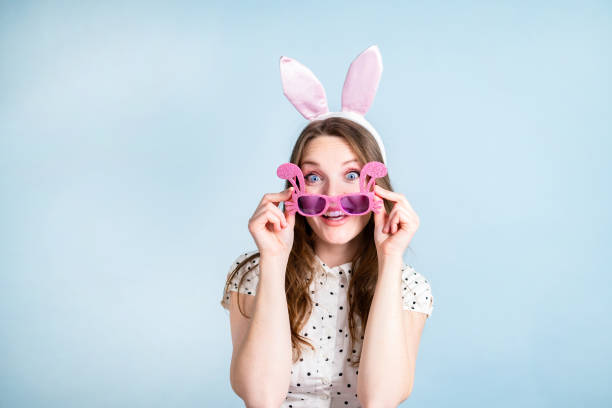 キラキラと輝くサングラスをかけて楽しんでいる女性が、カメラに驚いて見つめる。 - easter easter bunny fun humor ストックフォトと画像