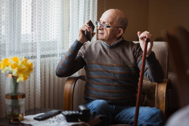 istock Senior man talking via smart phone and looking through window 1388819890