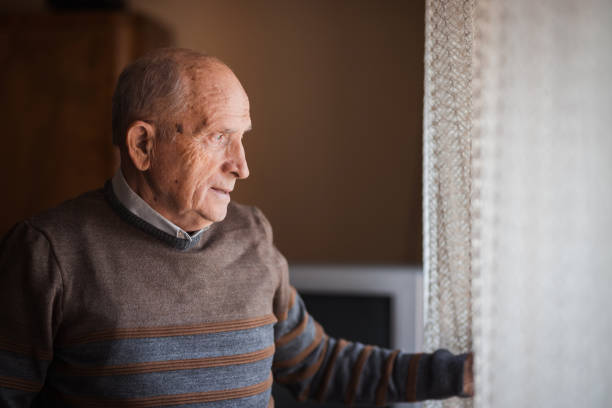 istock Elderly man removing curtains and looking through the window 1388820023