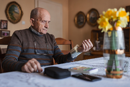 Mature man measuring his blood pressure at home